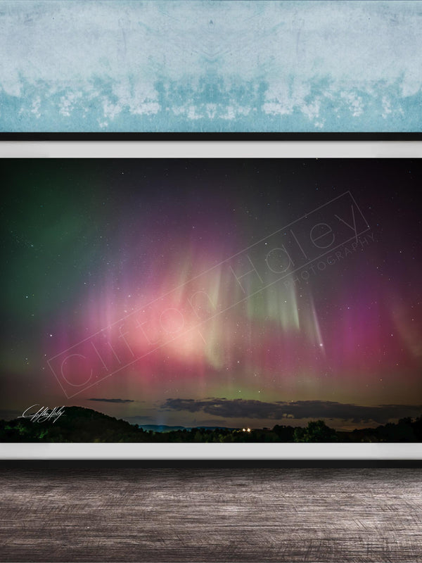 The image is a framed photograph of a night sky with the aurora borealis, or northern lights, visible.
