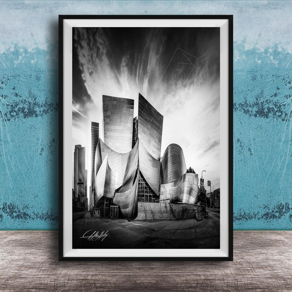 A black and white photograph of a modern, curved building with a distinctive architectural design, set against a cloudy sky.