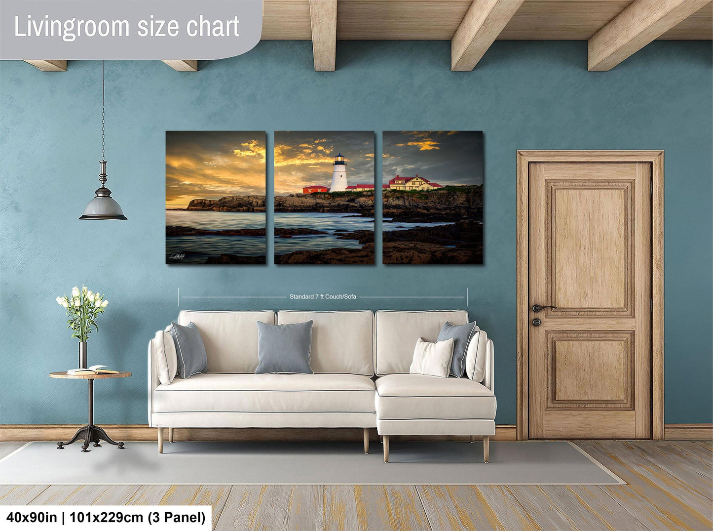 The image is a living room with a large painting of a lighthouse on the wall. The painting is divided into three panels, depicting a serene coastal scene. The room has a white sofa and a wooden door, creating a cozy and inviting atmosphere.