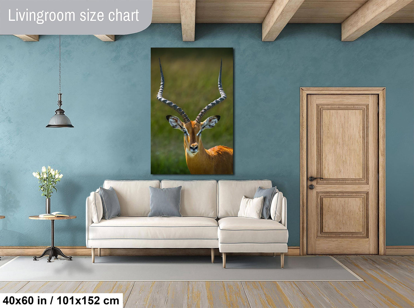 a living room with a large wall painting of an antelope, a white sofa, a wooden door, and a small table with a vase of flowers.