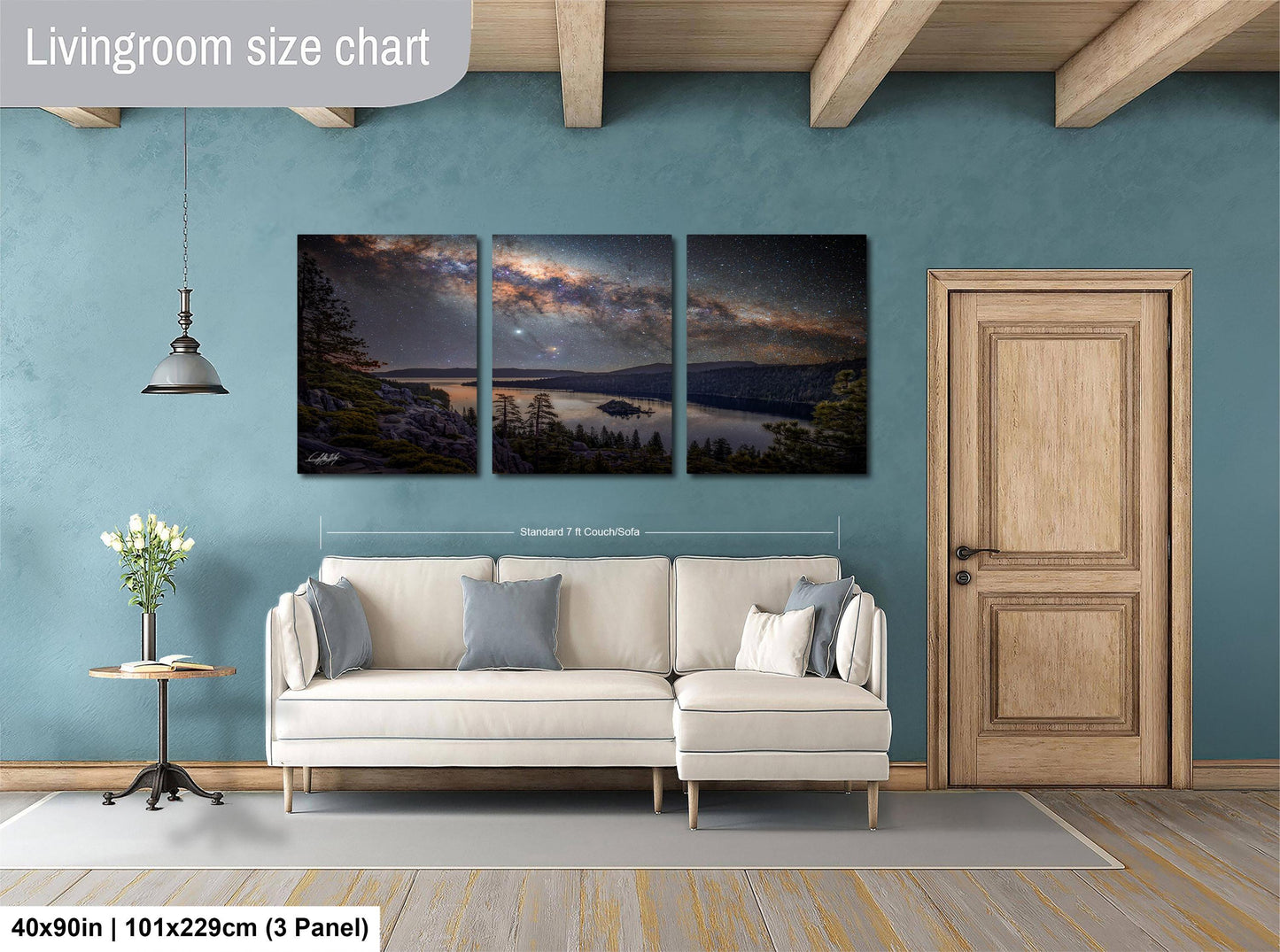The image is a living room with a large, three-panel landscape painting hanging on the wall. The painting depicts a serene night sky over a lake, with trees and mountains in the background. The room has a white sofa and a wooden door, creating a cozy and inviting atmosphere.