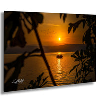 a serene sunset over a body of water, with a boat gently floating on the surface.