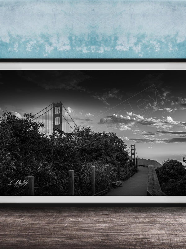 A black and white photograph of the Golden Gate Bridge in San Francisco, California, with a cloudy sky in the background.