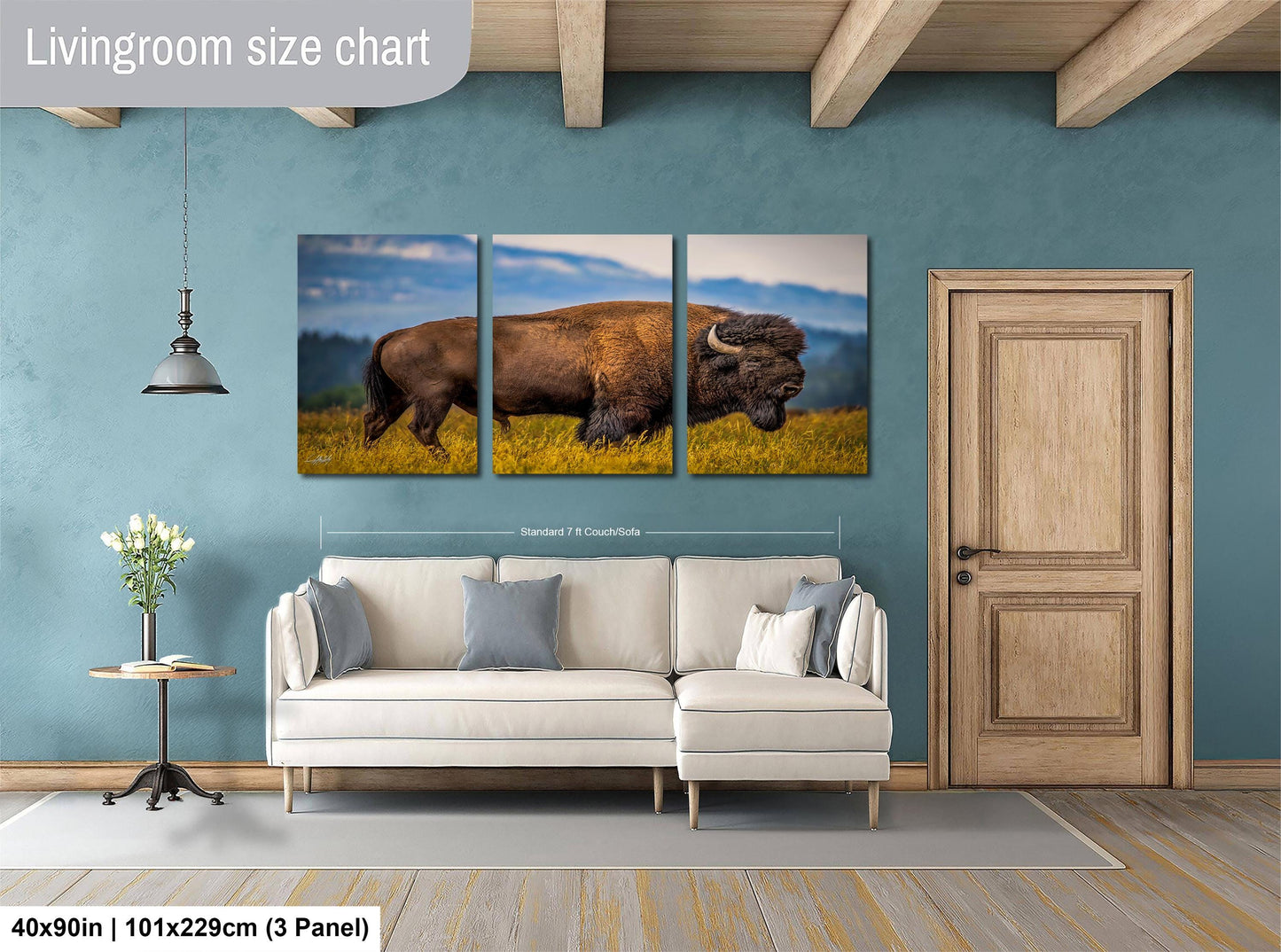 The image is a living room with a large painting of a bison in a field hanging on the wall. The painting is divided into three panels, with the largest panel covering the entire wall. The room has a white sofa, a wooden door, and a small table with a vase of flowers. The wall is painted in a light blue color, and the floor is covered with a gray rug. The image is described as a "Livingroom size chart" and includes dimensions of 40x50 inches (101x129 cm) and a 3-panel layout.