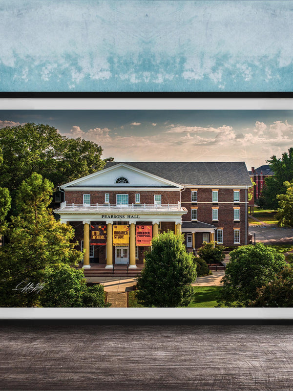 A framed photograph of the Peabody Hall building, a historic brick structure with a prominent pediment and columns, surrounded by trees and a blue sky.
