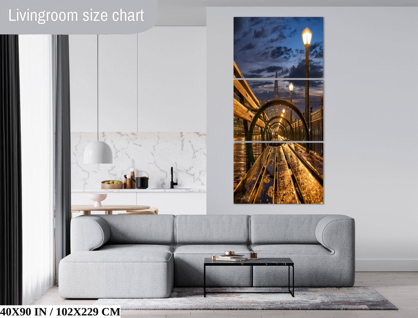 The image is a living room with a gray sofa, a coffee table, and a large wall art depicting a train tunnel at night.