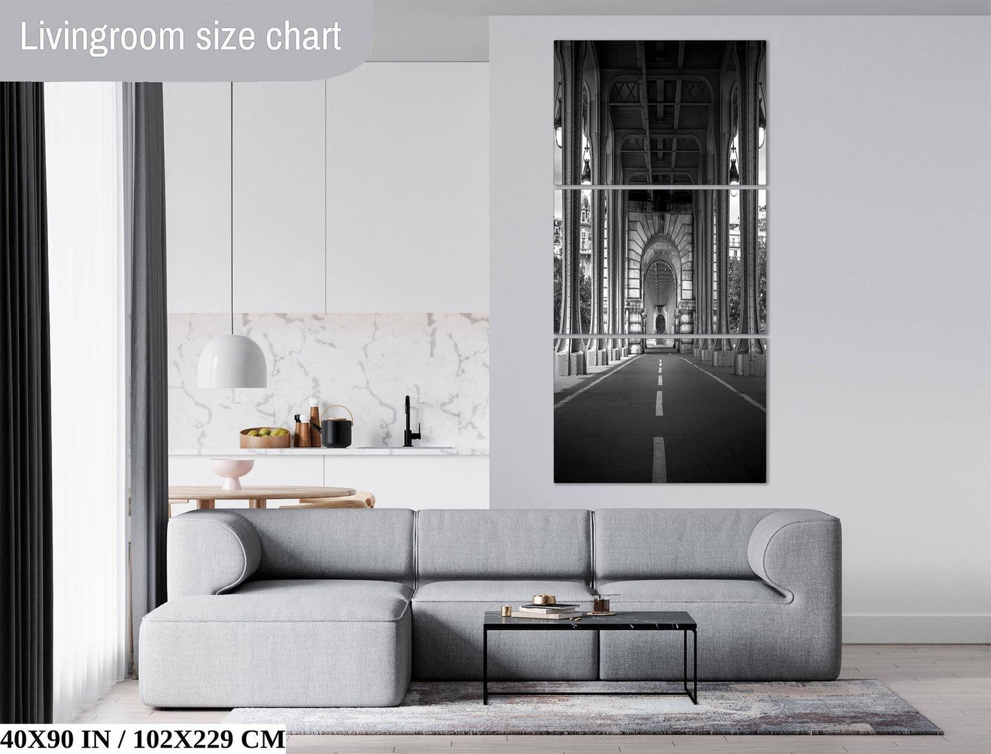 a modern living room with a gray sectional sofa, a glass coffee table, and a large black and white photograph of a bridge in the background.