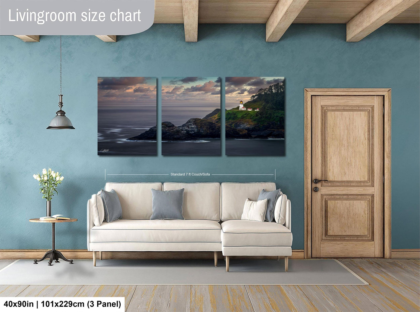 The image is a living room with a large white sofa, a wooden door, and a painting of a coastal landscape hanging on the wall.