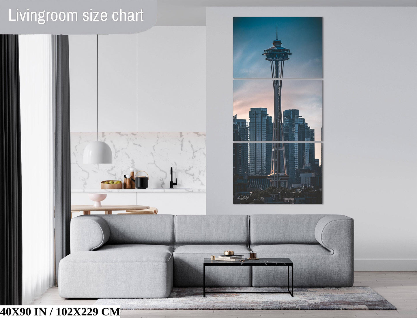 The image is a living room with a gray sofa, a coffee table, and a large wall art depicting the Space Needle in Seattle, Washington.