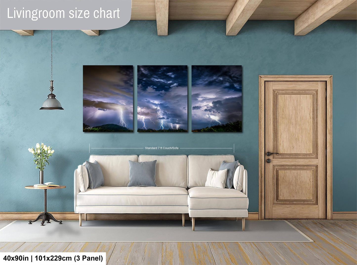 The image is a living room with a white sofa and a wooden door. Above the sofa, there is a large painting depicting a dramatic sky with lightning. The painting is divided into three panels, each showing a different part of the sky. The wall behind the sofa has a blue color, and there is a lamp hanging from the ceiling. The image is described as a living room size chart, indicating that it is a visual representation of the dimensions of the living room.