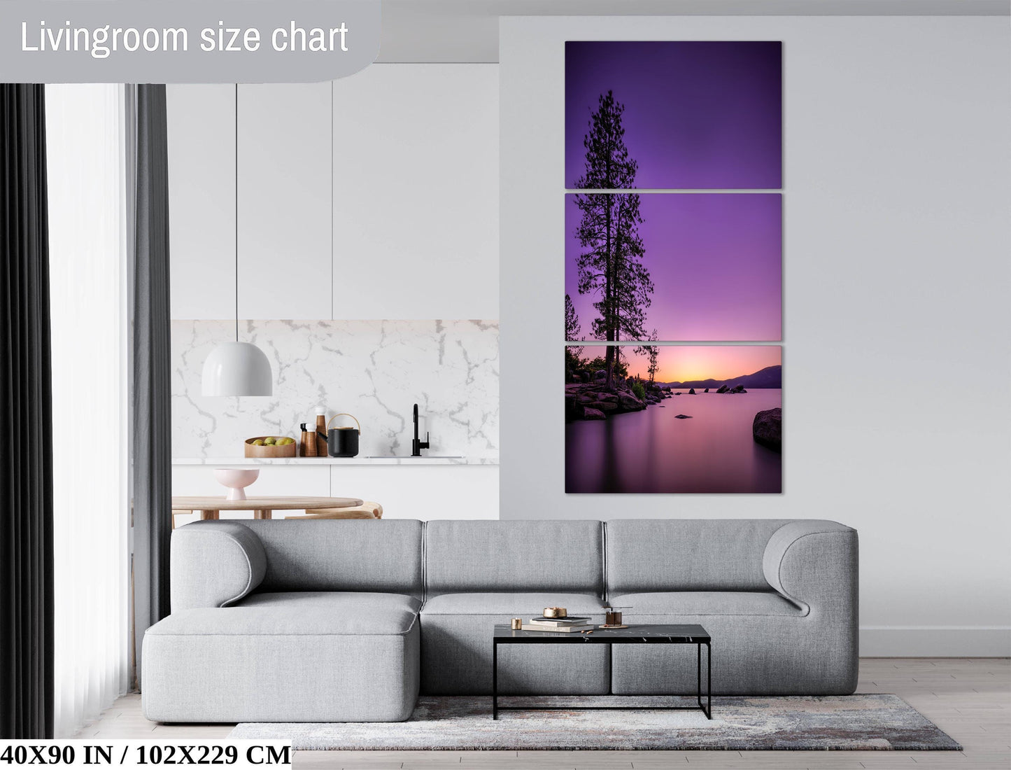 The image is a living room with a gray sofa, a coffee table, and a large wall art depicting a sunset over a lake.