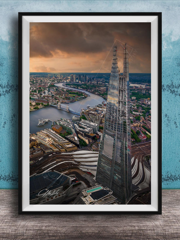 The image is a framed aerial view of the London skyline, showcasing the iconic Shard skyscraper and the River Thames in the background.