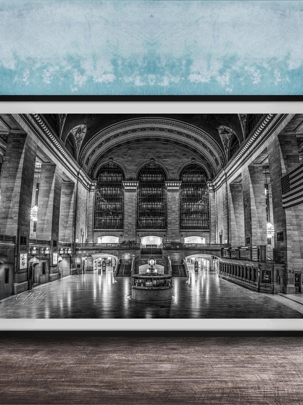 The image is a black and white photograph of a grand, ornate interior space with high ceilings, arched windows, and intricate architectural details.