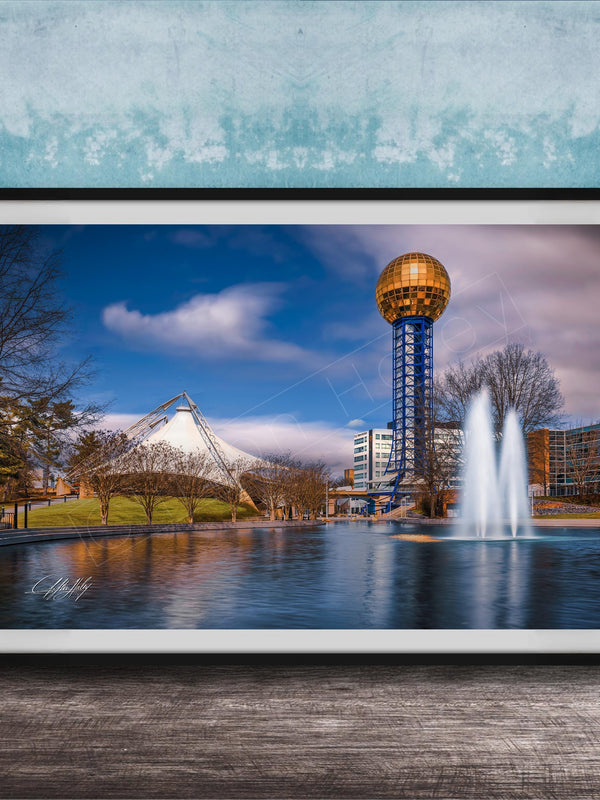 A framed photograph of the iconic Space Needle in Nashville, Tennessee, with a fountain in the foreground and a blue sky with clouds in the background.