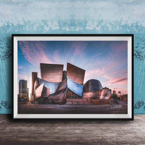 A framed photograph of the Guggenheim Museum in Bilbao, Spain, with its distinctive curved and metallic architecture against a colorful sunset sky.