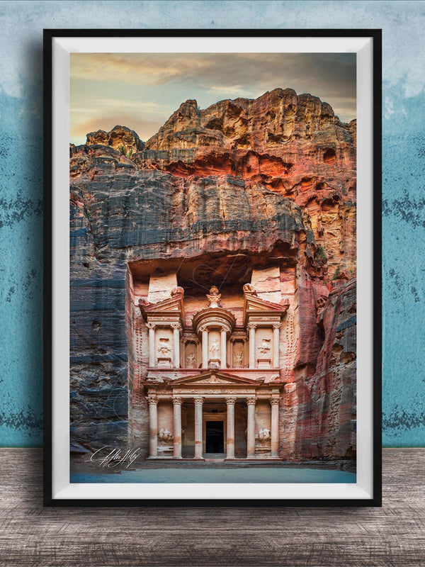 A framed image of the ancient Monastery carved into a cliff face, with a dramatic sky and rocky landscape in the background.