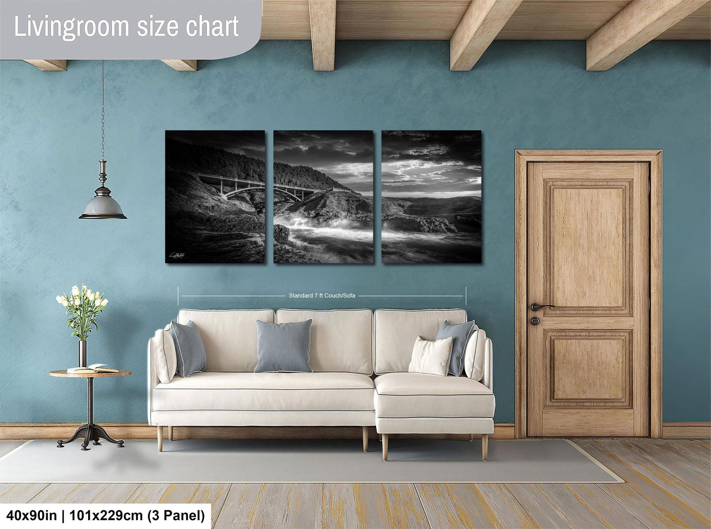 The image is a living room with a large white sofa, a wooden door, and a painting of a landscape on the wall.