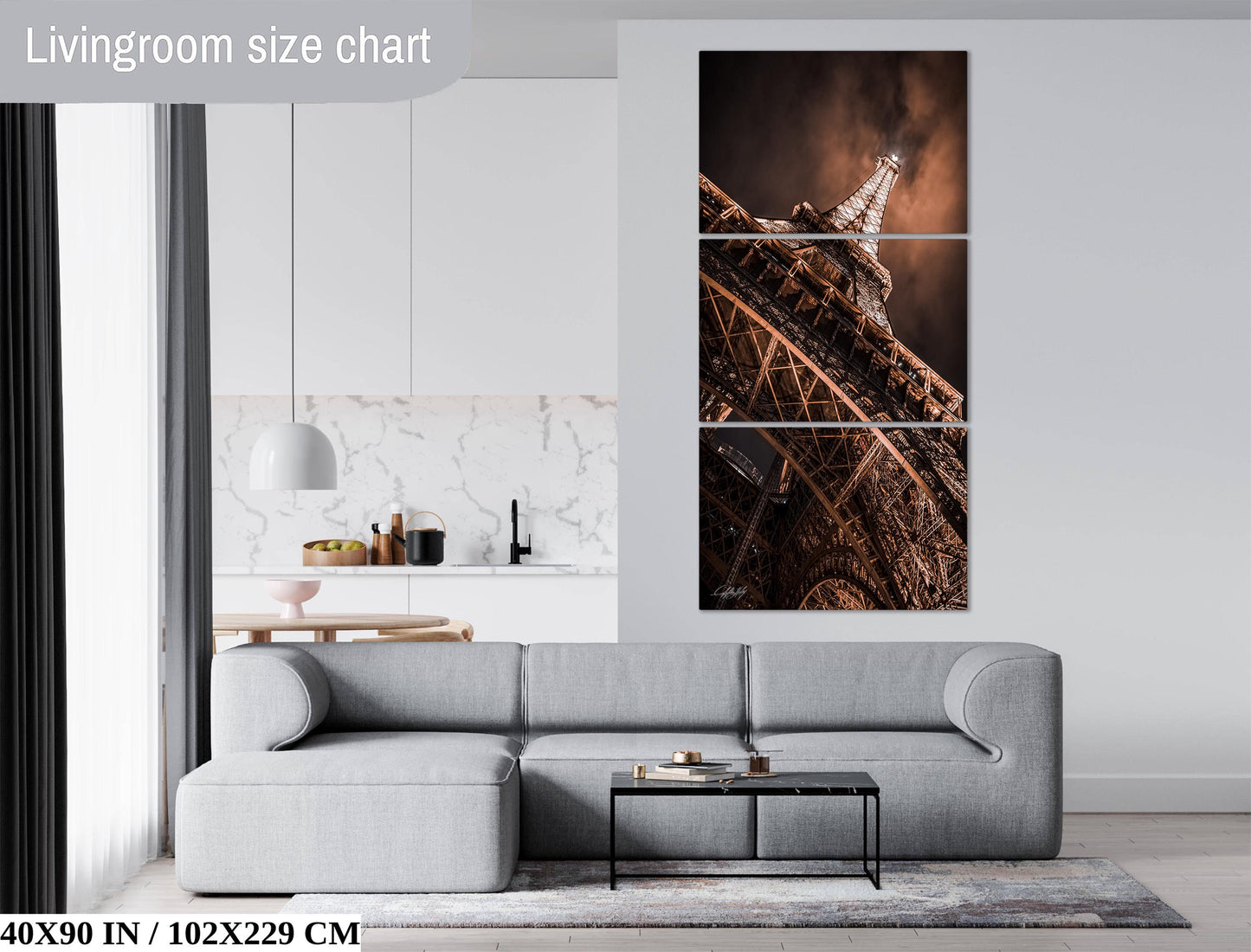 The image is a living room with a gray sofa, a coffee table, and a large wall art depicting the Eiffel Tower.