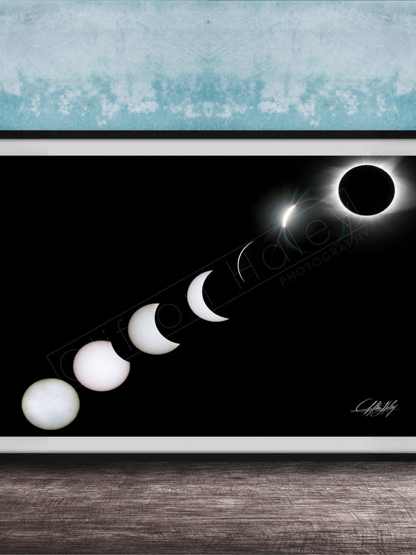 A framed image depicting the solar eclipse, showing the moon transitioning from a crescent to a full moon, with the sun partially obscured by the moon.