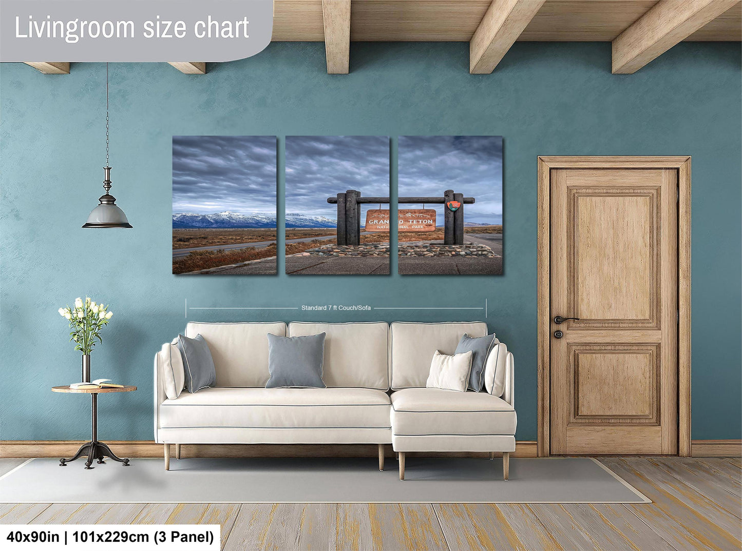 The image is a living room with a white sofa, a wooden door, and a wall with a large painting depicting a scenic landscape.