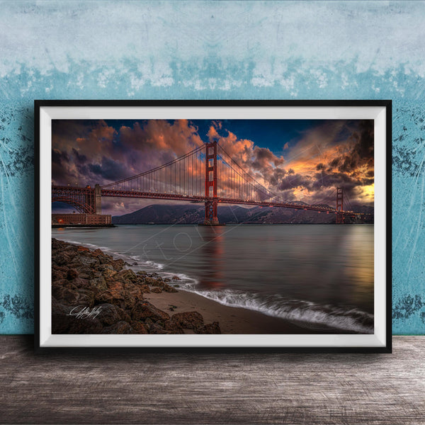 a stunning sunset over the Golden Gate Bridge, with the bridge's iconic red towers silhouetted against the vibrant sky. The calm waters of the bay reflect the warm hues of the setting sun, creating a serene and picturesque scene.