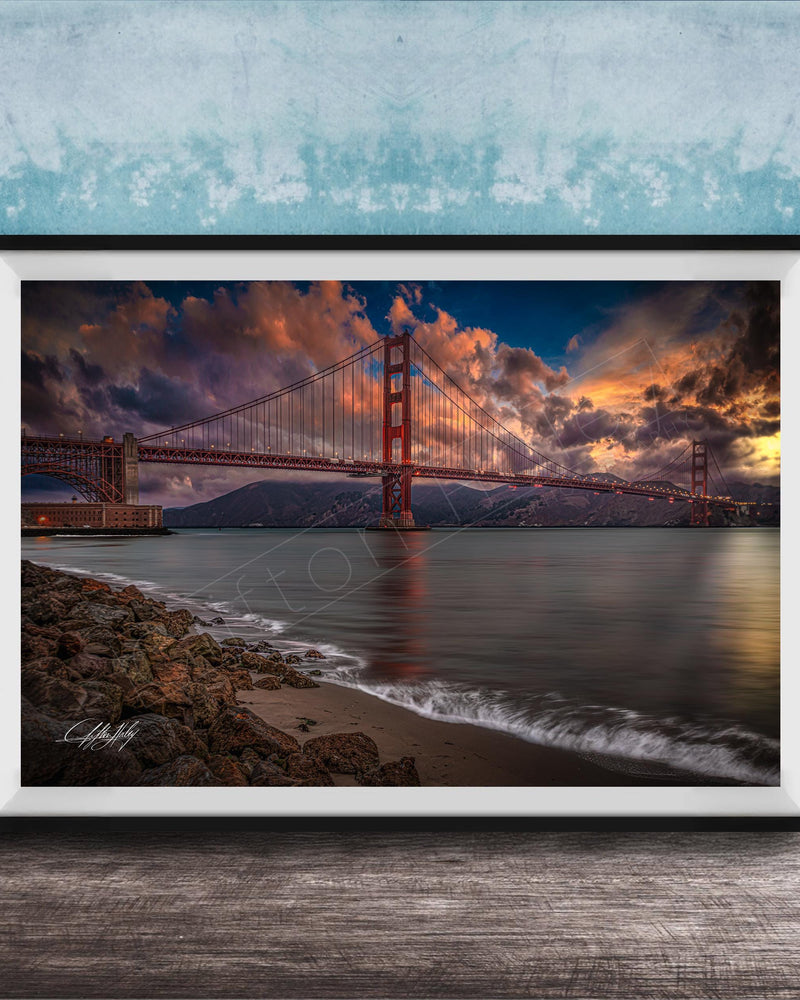 a stunning sunset over the Golden Gate Bridge, with the bridge's iconic red towers silhouetted against the vibrant sky. The calm waters of the bay reflect the warm hues of the setting sun, creating a serene and picturesque scene.