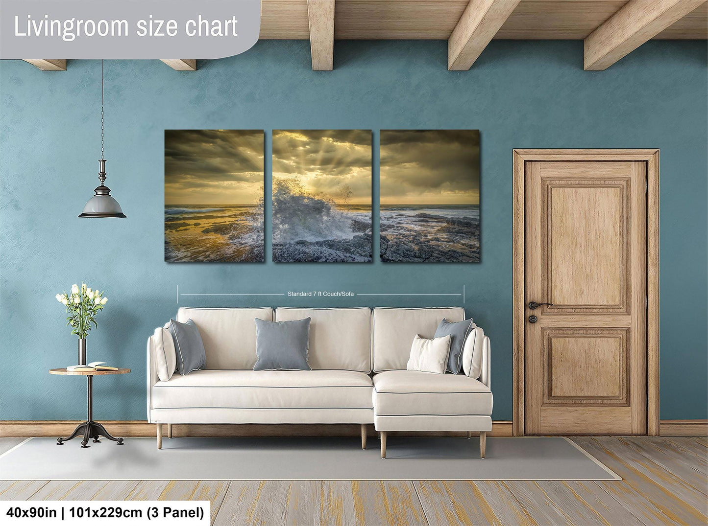 The image is a living room with a large white sofa, a wooden door, and a painting of a stormy ocean scene above it.