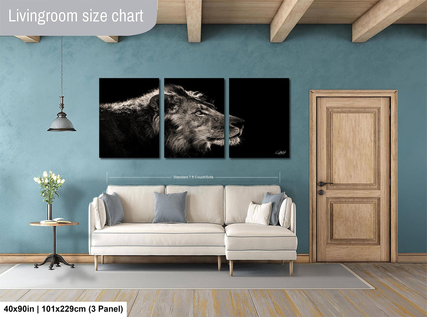 The image is a living room with a large wall art piece depicting a lion's head in black and white. The living room has a white sofa, a wooden door, and a wooden floor. The wall art is approximately 40 inches wide and 101.29 cm tall, with a 3-panel layout.