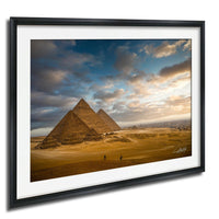 the iconic pyramids of Giza in Egypt, with a dramatic sky and clouds in the background.