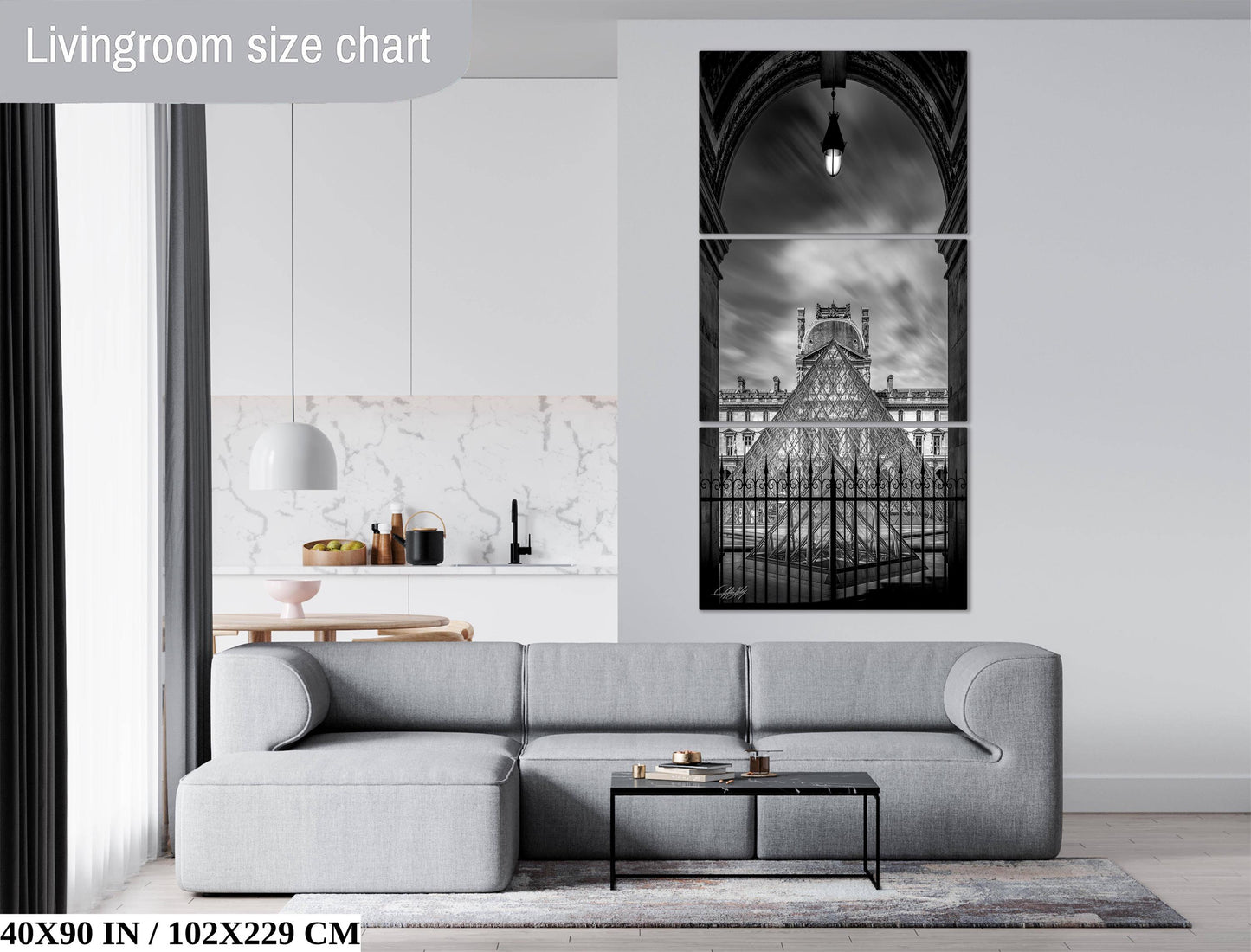 The image is a living room with a gray sofa, a coffee table, and a large black and white photograph of a cathedral or church in the background.