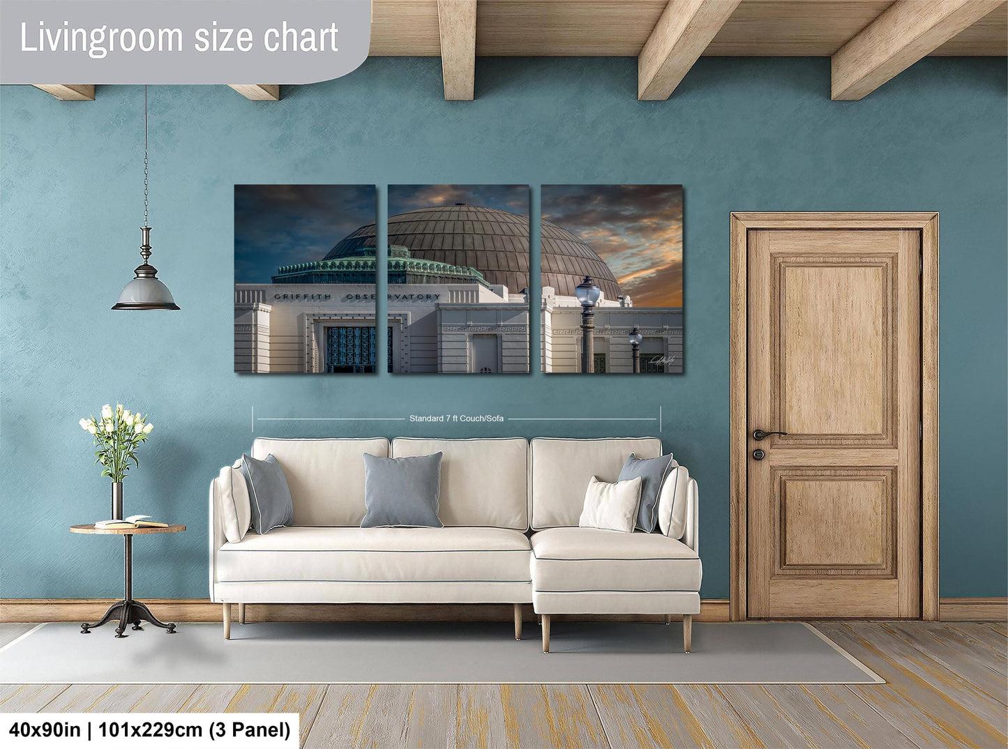 The image is a living room with a white sofa and a wooden door. Above the sofa, there is a large wall art depicting a building with a dome. The wall art is divided into three panels, each showing different parts of the building. The living room has a blue wall and a wooden floor.