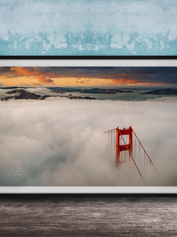 A framed photograph depicting the Golden Gate Bridge in foggy conditions, with the bridge's iconic red towers visible through the mist.