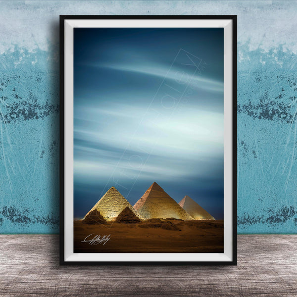 A framed photograph of the iconic pyramids of Giza in Egypt, with the sky and clouds in the background.