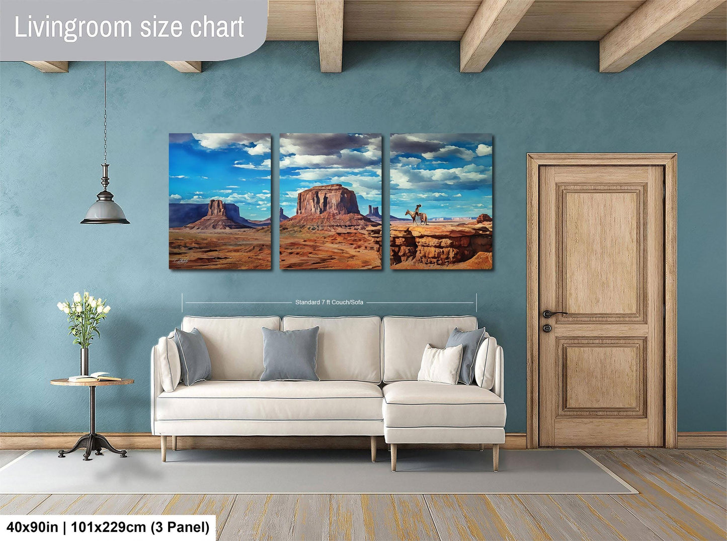 The image is a living room with a large wall art depicting three desert scenes, including a mountain range and a desert landscape. The wall art is mounted above a white sofa, and there is a wooden door and a small table with a vase of flowers in the room.