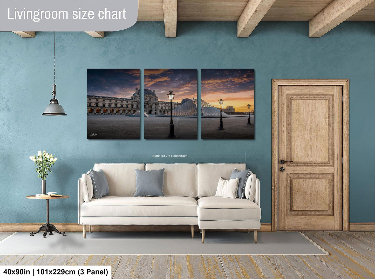 The image is a living room with a white sofa and a wooden door. Above the sofa, there is a living room size chart that provides dimensions for the artwork displayed on the wall.