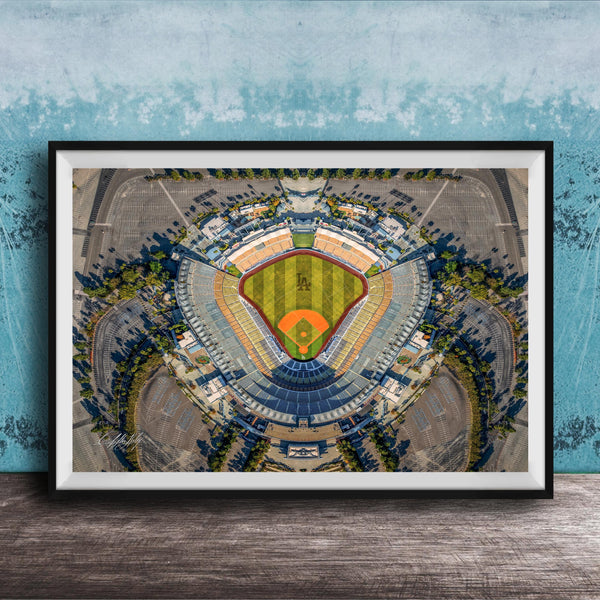 The image is an aerial view of a baseball stadium, featuring a large field surrounded by parking lots and other structures.
