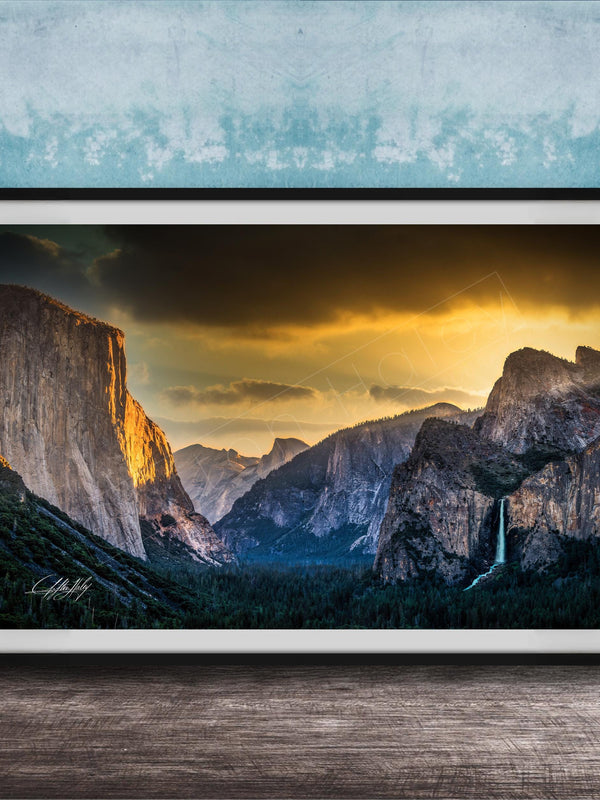The image is a framed photograph of a breathtaking mountainous landscape at sunset, with dramatic clouds and a waterfall in the foreground.
