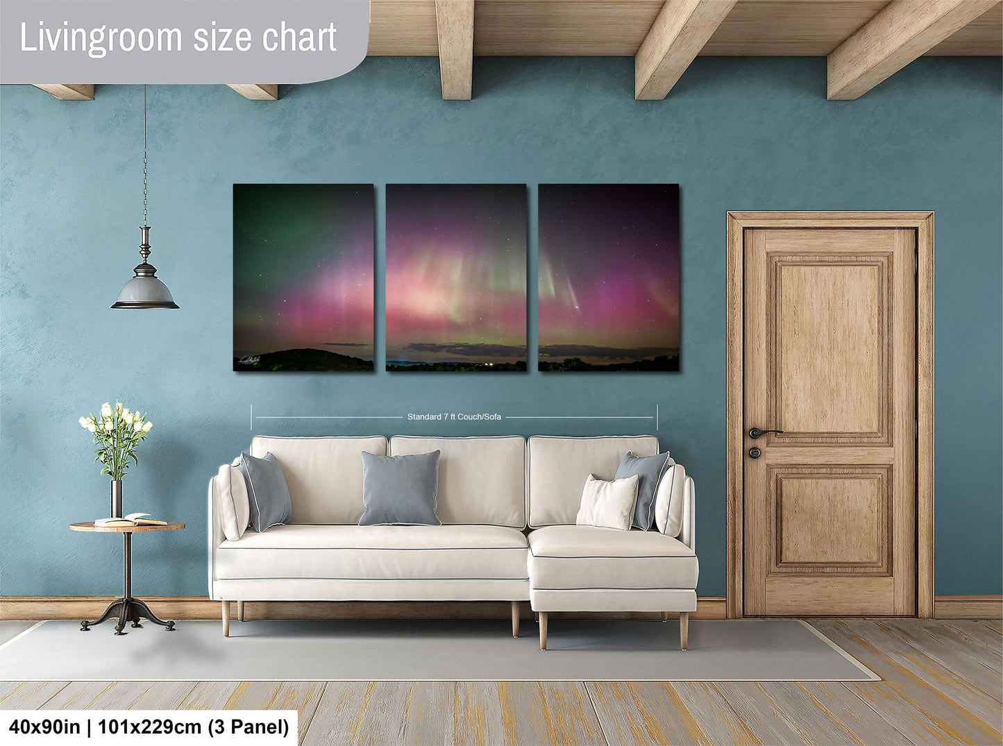 The image is a living room with a large, three-panel print of a night sky displaying the Aurora Borealis ( Aurora ) on the wall. The print is framed by a wooden door and a white sofa.