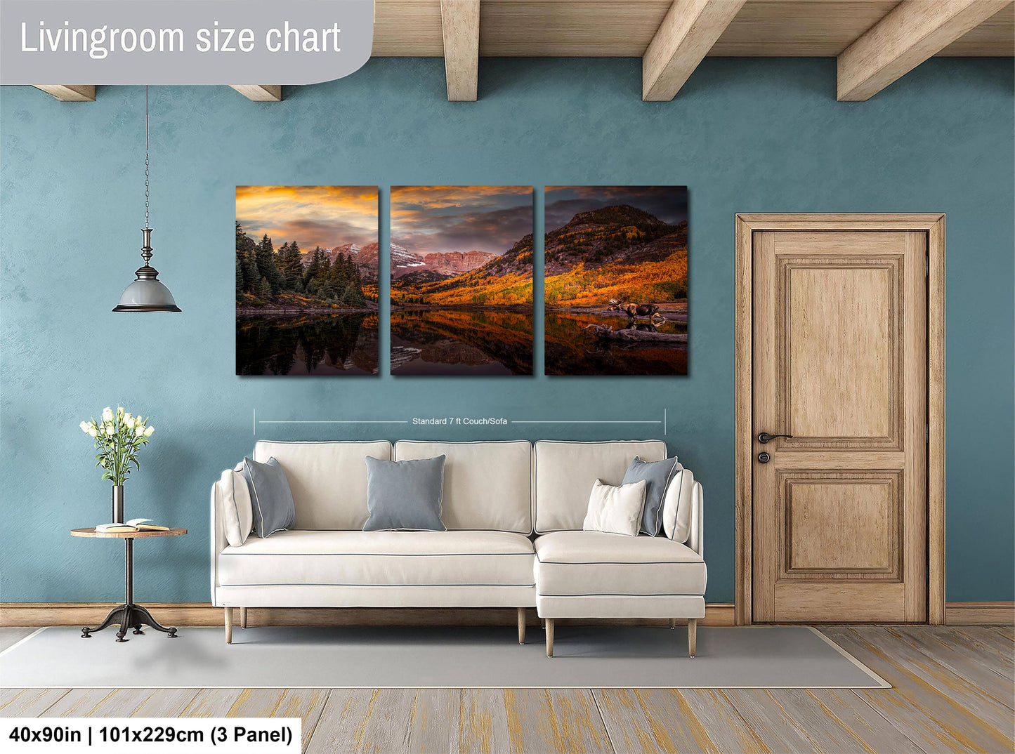 The image is a living room with a large, three-panel landscape painting hanging on the wall. The painting depicts a scenic mountain landscape with a lake and trees. The room has a white sofa and a wooden door, creating a cozy and inviting atmosphere.