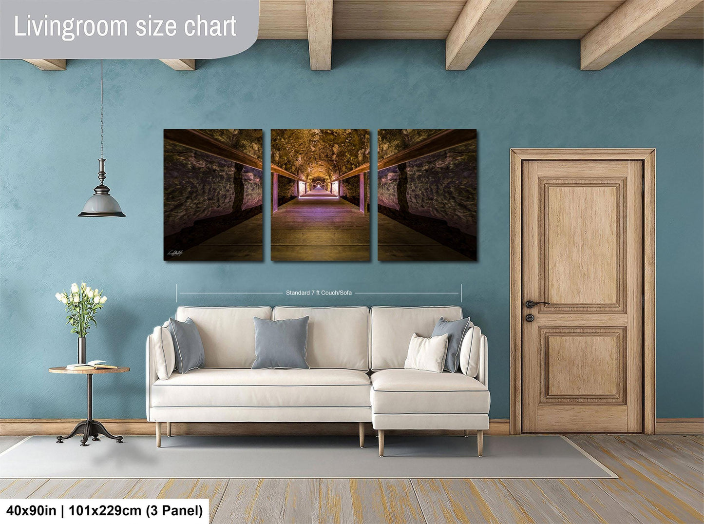 The image is a living room with a large white sofa, a wooden door, and a hanging light fixture. Above the sofa, there is a triptych of artwork depicting a tunnel with a purple light at the end. The artwork is framed and hangs on the wall, creating a cohesive and visually appealing space.