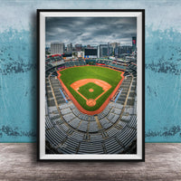 A framed photograph of a baseball stadium with a city skyline in the background.
