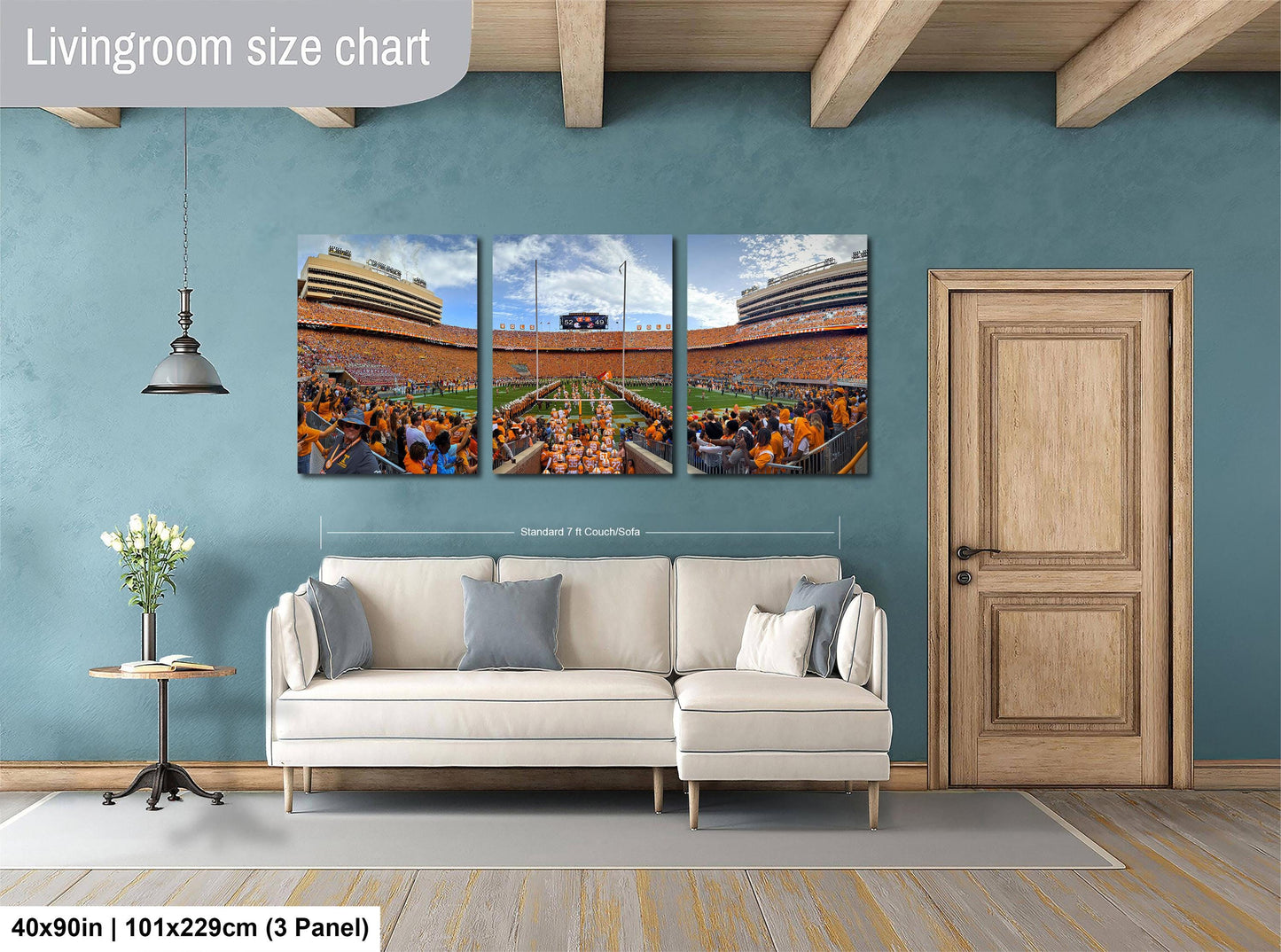 The image is a living room with a large wall art depicting a football stadium. The wall art is divided into three panels, each showing different aspects of the stadium, such as the field, the crowd, and the scoreboard. The living room has a white sofa and a wooden door, creating a cozy and comfortable atmosphere.