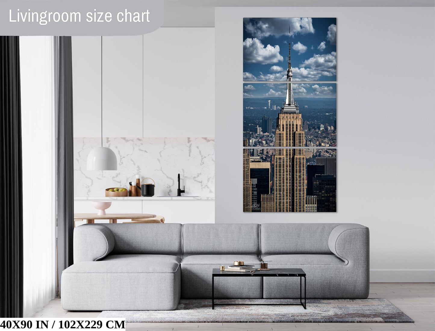 a modern living room with a gray sofa, a coffee table, and a large wall art piece featuring the Empire State Building.