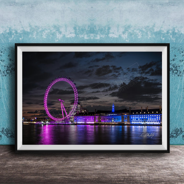 A large Ferris wheel illuminated in purple and blue lights stands against a dark sky, with a city skyline in the background.