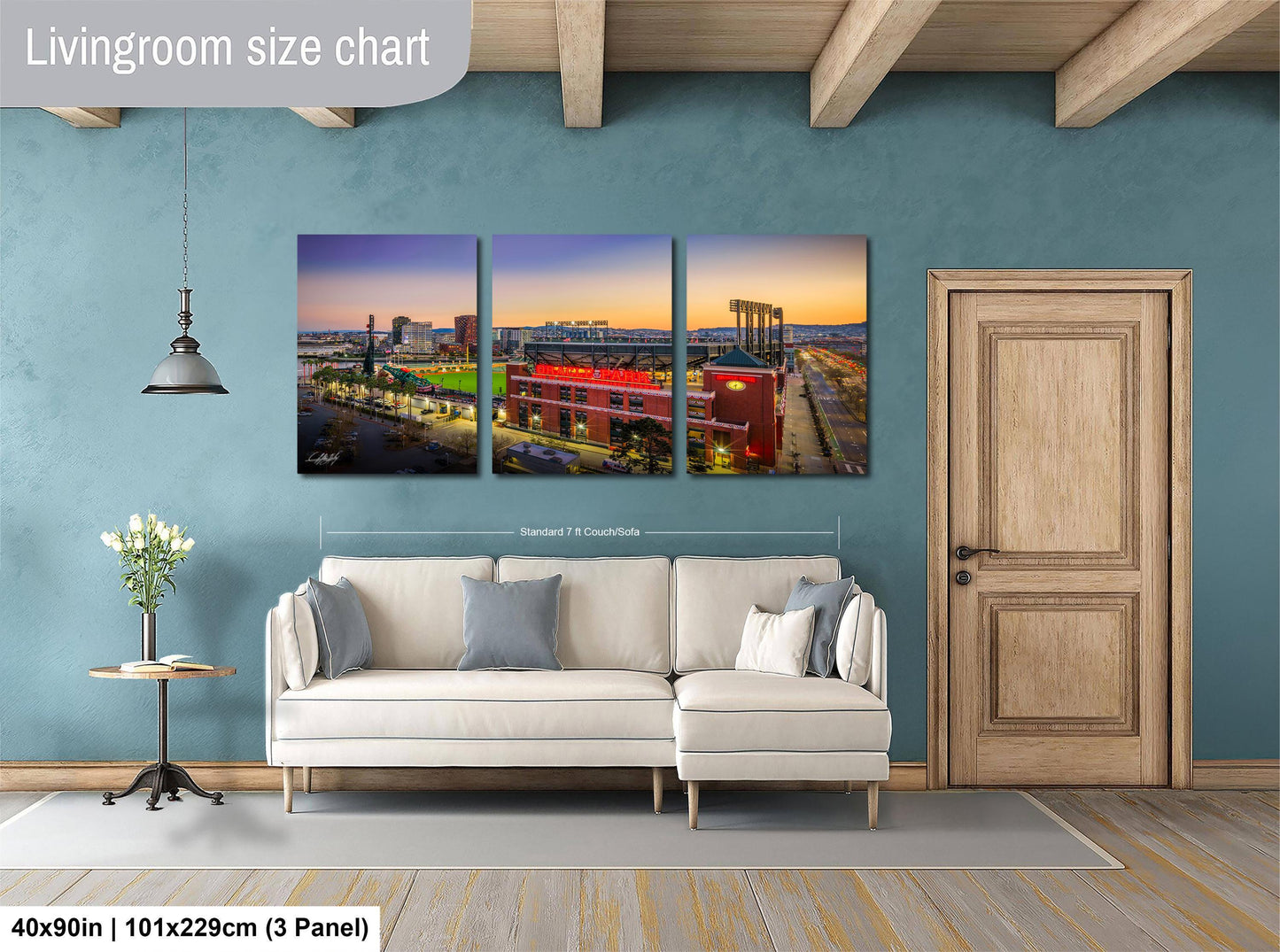 The image is a living room with a large wall art collage depicting a city skyline at sunset. The collage consists of three panels, each showing a different view of the cityscape. The collage is framed by a wooden door and a white sofa, creating a cozy and inviting atmosphere.