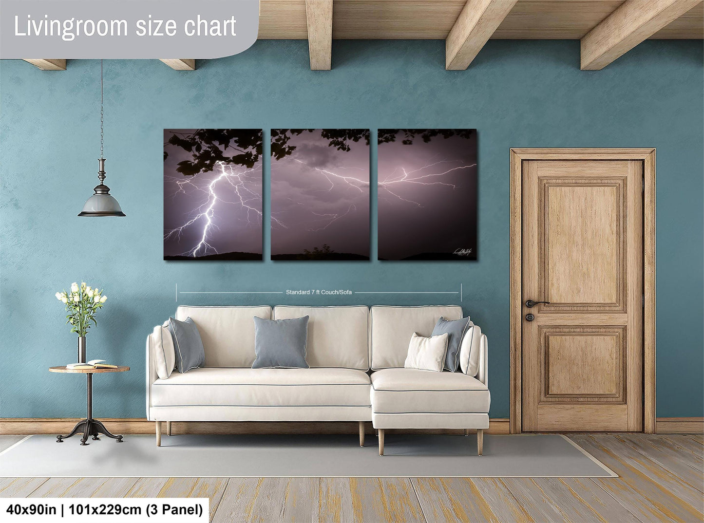 The image is a living room with a white sofa, a wooden door, and a large wall art depicting a dramatic lightning storm.