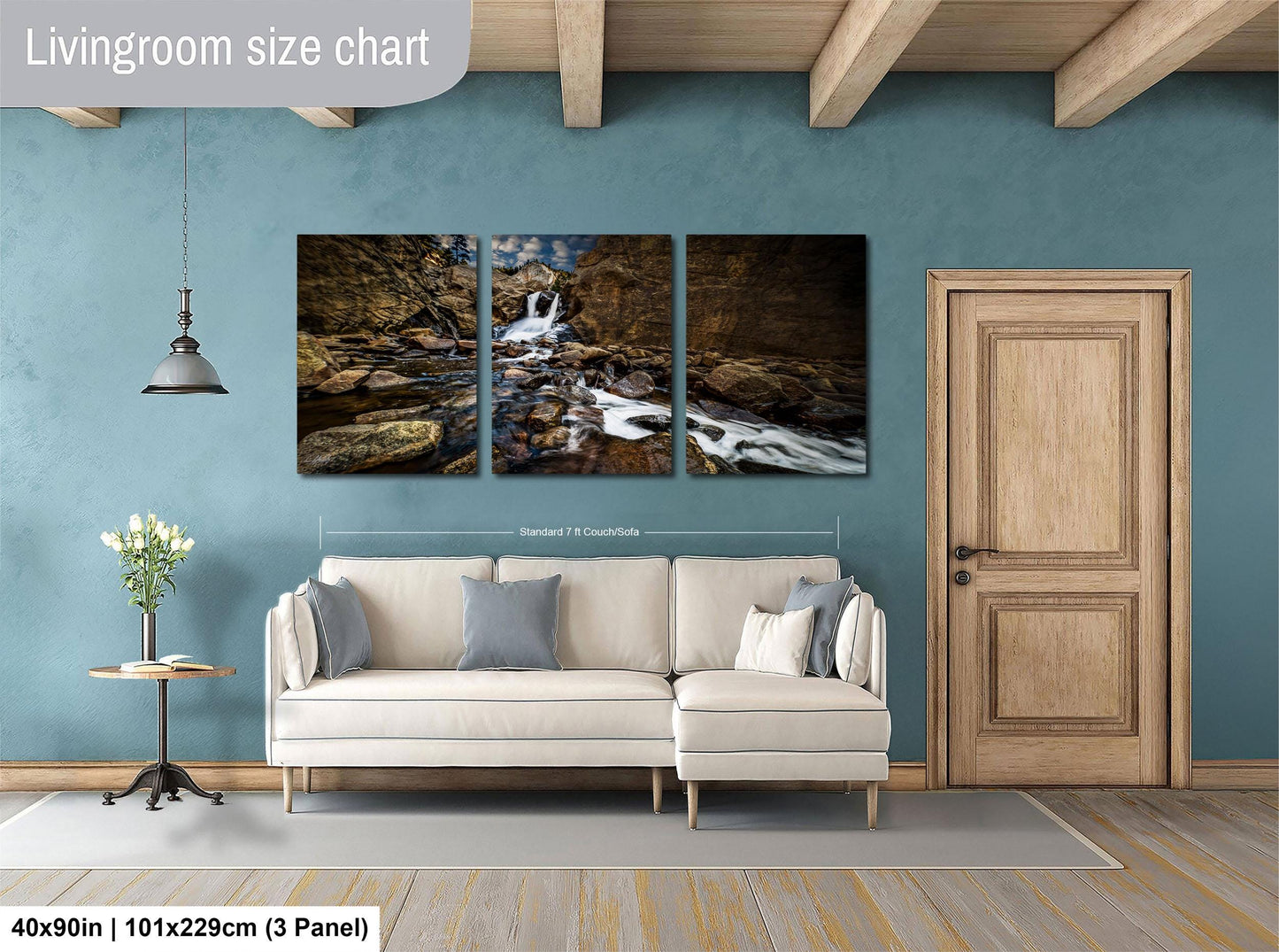 The image is a living room with a large white sofa, a wooden door, and a hanging light fixture. Above the sofa, there is a large living room size chart that provides dimensions for the artwork displayed on the wall.