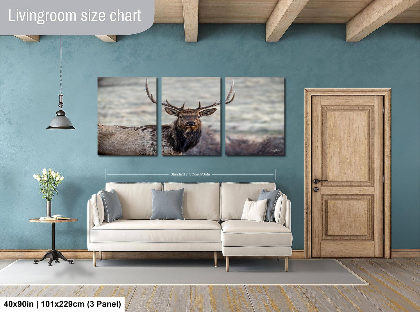 The image is a living room with a large white sofa, a wooden door, and a painting of a deer on the wall.