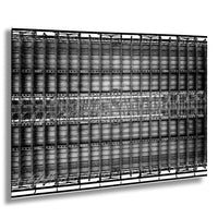 The image is a black and white photograph of a large metal structure, possibly a building or a large metal frame, with numerous interconnected metal beams and panels arranged in a grid-like pattern.