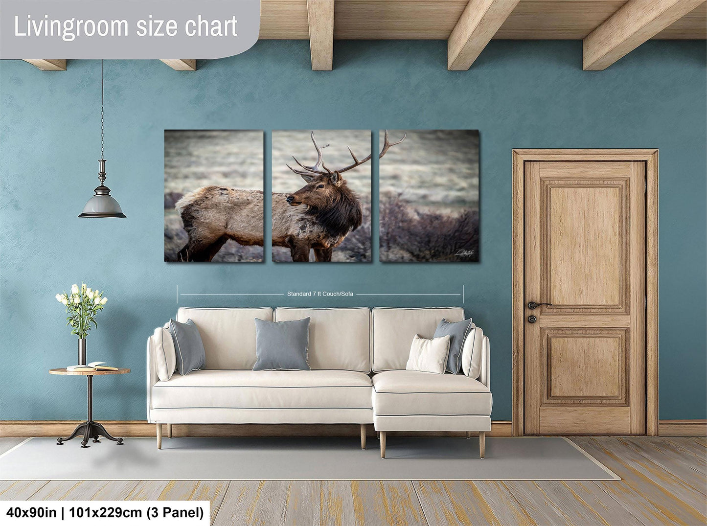 The image is a living room with a large painting of a deer on the wall. The painting is divided into three panels, with the largest panel covering the entire wall. The room has a white sofa, a wooden door, and a wooden beam ceiling. The wall is painted in a light blue color, and there is a vase of flowers on a small table. The image is described as a living room size chart, indicating that it is a scale model or a representation of the actual room.